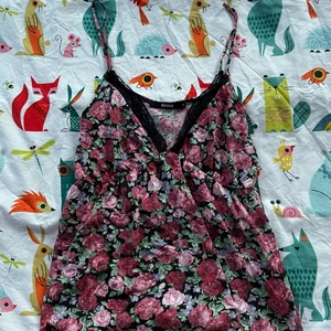 Blommigt linne - Säljer ett blommigt linne med spets och djup urringning så att man ser lite klyfta! Jättemysigt och skönt tyg