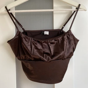 Brun topp - Toppen är från hm och använd 1 gång. Den har jätte skönt silkes material och är perfekt längd. Jätte fin till sommaren. 