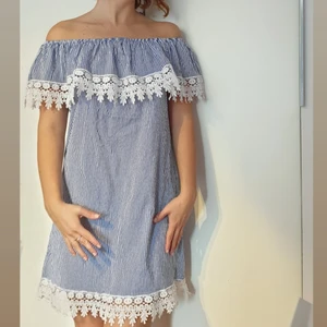 Blåvit strandklänning, storlek S - Strandklänning blåvit, pösig med elastiskt band kring axlarna( lätt att ta på under bikini/baddräkt ) 100 % Bomull.