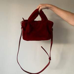 En röd supermjuk ”päls”-väska från Bershka. Den har en avtagbar justerbar rem och stängs med en fungerande dragkedja. Använd endast ett fåtalgånger så är som i nyskick. FRAKT tillkommer från 66kr. 