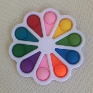 Dimple Digit - Den är rosa, gul, ljusgrön, mörkblå, orange, lila, mörkgrön, ljusblå och röd. Den låter bra när man poppar den och den har 10 pops.