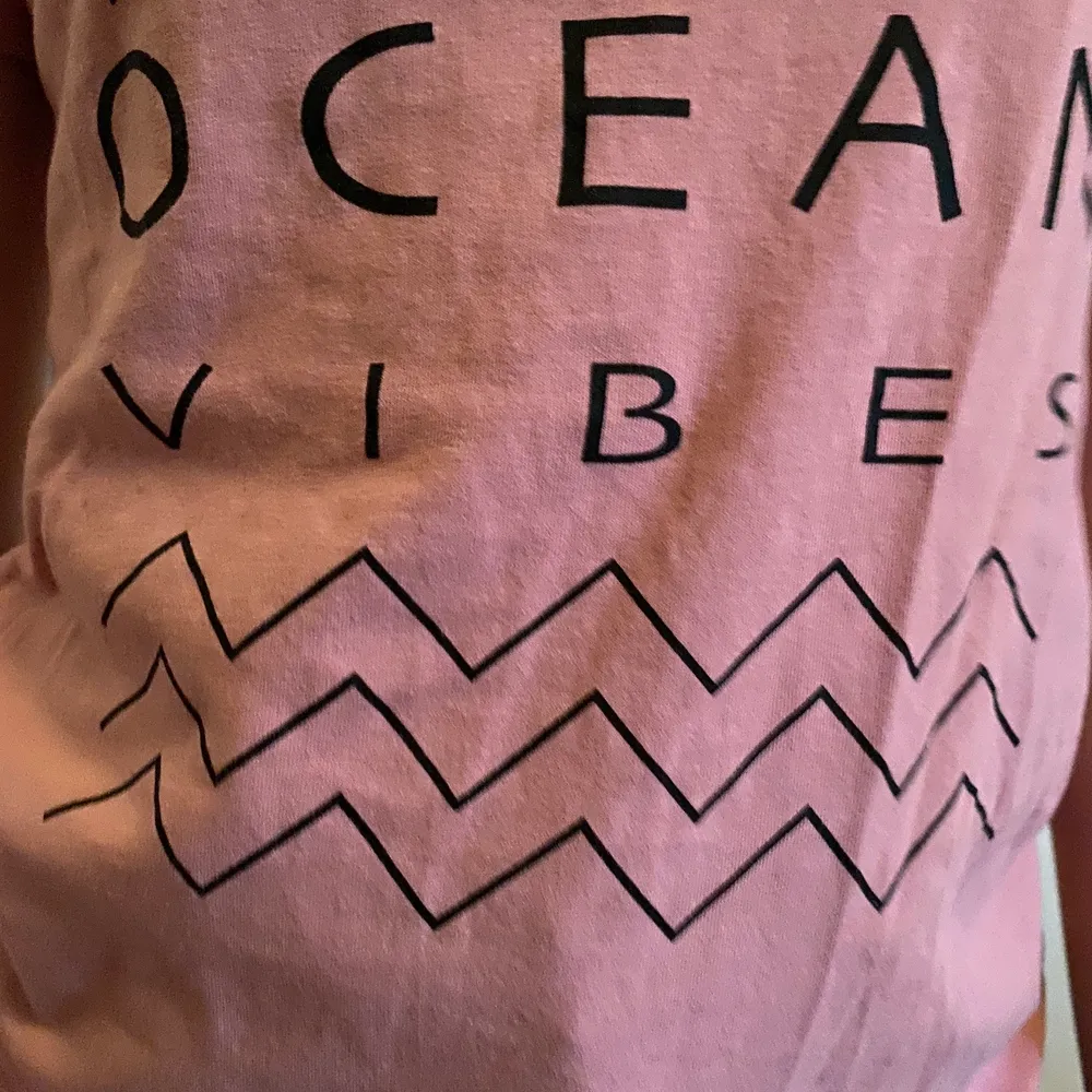 En rosa tröja med en text där det står ”ocean vibes” på i svart text. Skönt material och ett mönster under texten. frakt ingår. Tvättar såklart innan frakt. . T-shirts.