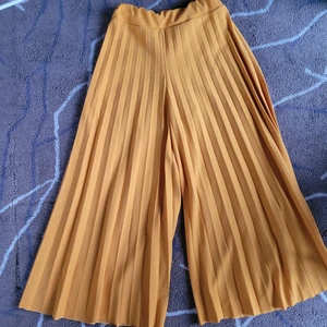 Plisserade sommarbyxor XS  - Vänligen läs noga innan du köper. Gula plisserade byxor.i storlek XS. Köparen står för all eventuell fraktkostnad. Varan skickas när betalningen gjorts. 