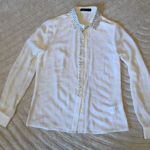 Finblus med strassstenar - Underbar vit blus med strass på krage o framtill. Fin nu på sommaren till kjol o shorts