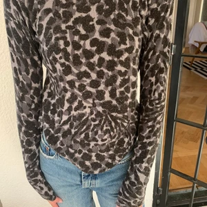 Stickad tröja i leopardmönster - Trendig tunnstickad tröja i grått leoprdmönster, passar XS/S beroende på hur man vill att den sitter🥰