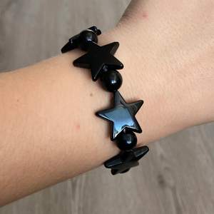 Svart elastiskt armband med stjärnor, frakt frimärke 12:- 💌