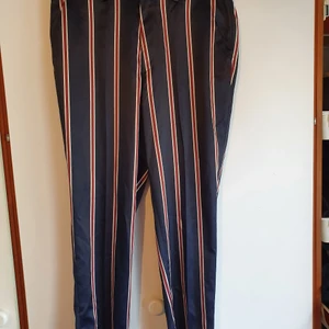 Asos randiga byxor - Randiga byxor från Asos. Lite ovanligt material som känns ungefär som silke och är lite "glansigt". Känns tajtare än W32. Endast använda ett par ggr så fint skick!😎