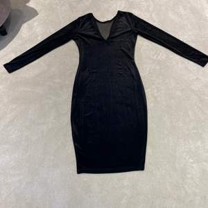 En svart V-ringad sammet klänning. Använd bara 1 gång. Längd= 94,5cm bredd i midjan 38cm arm längd 58cm.