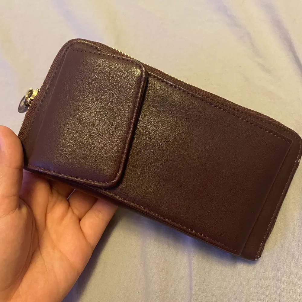 En plånbok med telefon hållare, aldrig använd i fint skick. Kommer även med ett snöre att kunna hålla den med.. Övrigt.