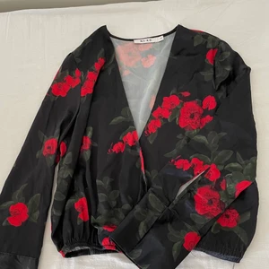 Blus med rosor - En bedårande blus med rosor från NA-KD i storlek 36. Pris: 90kr. Finns i Halmstad eller Kalmar annars står köparen för frakt. 