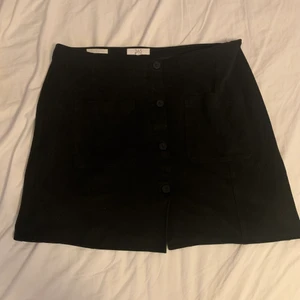 Kjol med knappar framtill - ✨En fin svart kjol med knappar framtill. Den är strl L och sitter fint. den har ett sammetsliknande tyg som är ganska tjockt. Köparen står för frakt✨ 