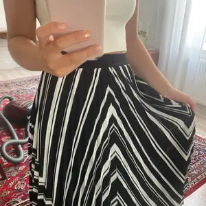 En svartvit mönstrad plisserad kjol från HM i bra skick. Den är i Stl XS men är ganska stor i storleken och passar därför en S också. 