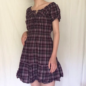 Rutig lila klänning puffärmar - Såååå fin rutig klänning med puffärmar i 100% bomull, går att ha off the shoulders eller som vanligt. Lite skrynklig men annars perfekt skick, Den är lila/plommonfärgad och är ”scrunchy” /stretchig i midjan. Stl M men passar nog också lite mindre och större, jag som är stl s kan ha den. Från märket bondelid.