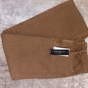 Jeans  - Helt nya bruna jeans är långa och har en straight fit. Är små i storleken så passar på en med storlek 36.