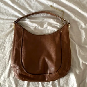 Brun väska  - En brun handväska med gulddetaljer! Från märket Aldo. Bredd: 35 cm, djup: 10cm, höjd: 35cm.      Köparen står för fraktkostnaden😊