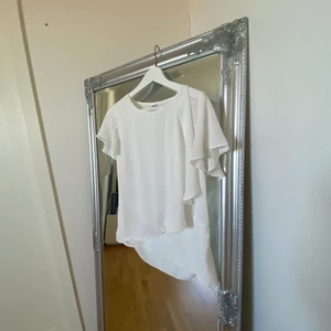 Vit blus med volang  - En supergullig och fin vit blus från märket SAINT TROPEZ i storlek XS. Passar superbra till ett vad basic byxor då volangen på blusen gör mycket till själva outfiten. 