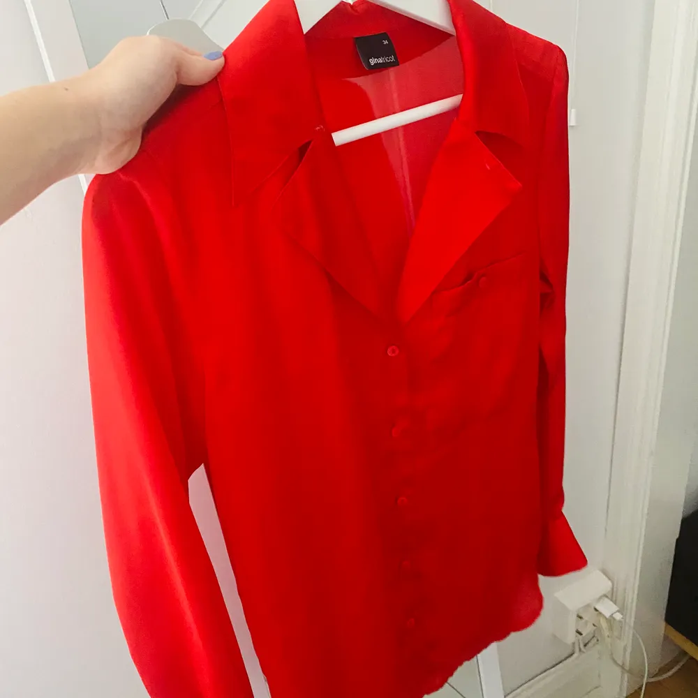 Röd skjorta i satin, snygg både knäppt och uppknäppt . Skjortor.