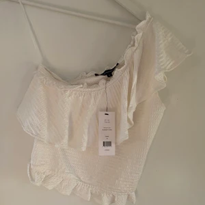 Vit topp - En vit one shoulder topp från french connection, aldrig använd så helt ny. Köpt för 500kr på asos. Köparen står för frakten 