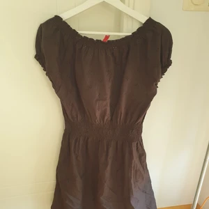 Snygg svart broderidekorerad klänning säljes - Svart klänning med mindre puffärmar. Klänningen är dekorerad med små blombroderier. Elastiskresår i midja, ringning och ärmslut. Skick som ny. 