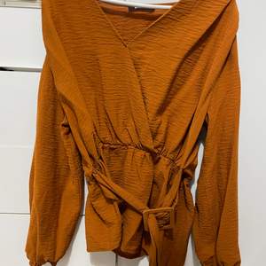 Fin orange tröja med bälte vid magen 