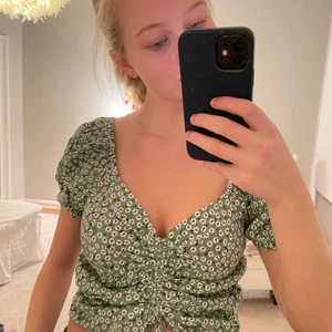 Topp från H&M - Jag säljer en jättefin topp från hm med blommönster. Den är aldrig använd och är i storlek M, men jag med storlek S kan ha den då det går att justera hur tajt den sitter.