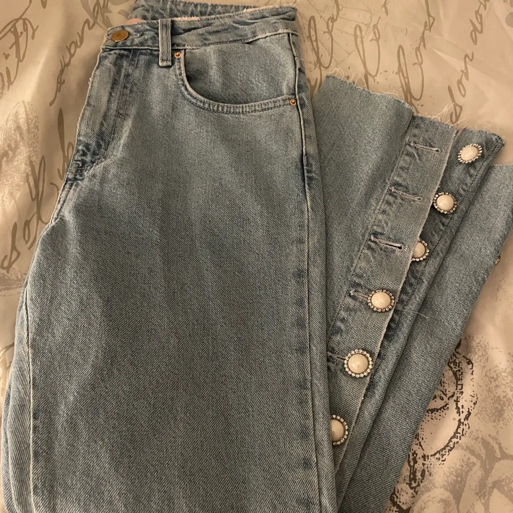 Riktigt snygga utsvängda jeans i storlek S som jag köpte för ett par år sen som jag tyvärr inte använde och nu passar de inte längre🥲. Fina knappar med detaljer som du kan knäppa upp eller stänga helt och riktigt fina detaljer baktill. 90-tals jeans🥰. Tar swish och fraktar antingen med spårbar frakt eller ej. Köparen bestämmer ☺️. Jeans & Byxor.