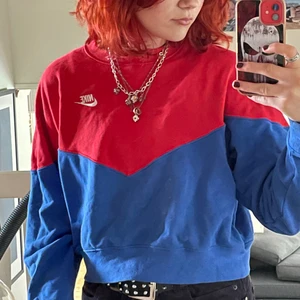 Nike sweatshirt - Jättesnygg nike sweatshirt i färgerna blå och röd i en gullig modell. Den är i storlek L så den är ganska oversized i ärmarna och ganska kort i modellen😁. Den är i mycket bra skick!! Köparen står för frakten! Budgivningen avslutas 4/7