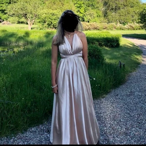 Balklänning i siden - Afton/balklänning i finaste siden, vackert draperad över brösten samt band som går från varsin axel i kors bak på ryggen som sedan snurras runt midjan för att knytas. Klänningen har också en slits framtill i två lager av siden i kjoldelen. Använd en gång, kemtvättad, prislapp finns kvar, nypris 2 300 kr. Storlek S. (Köparen står för frakt)