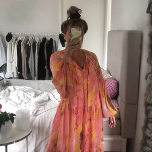 Klänning från Nakd  - Säljer min jättefina maxiklänning från nakd. Aldrig använd. Storlek 34. Klänningen går i rosa, orange och gula färger. Super bekväm och tar man ut underklänningen som medföljer kan man även använda den som strandklänning. Köparen står för frakt. Köpt för 500kr, jag säljer den för halva priset.