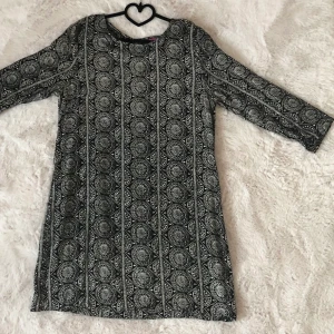 Klänning  - Klänning med jättefint mönster. När jag kunde få plats i denna klänningen älskade jag den, den är verkligen så skön. Klänningen slutar ovanför knäna (jag är 169cm) och armarna slutar ungefär vid mitten av underarmen.