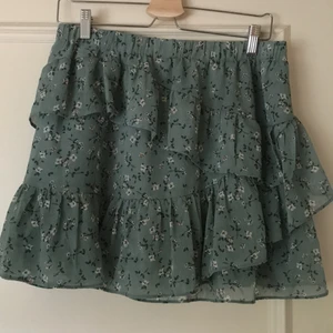 Ljusgrön blommig volangkjol - Jättesöt volangkjol! Kort modell men absolut inte för kort. Skönt resårband i midjan. Använt en del men den är inte illa medtagen. Storlek Xl men skulle säga mer M/L. Möts gärna upp i Stockholmsområdet men kan även frakta. Köparen står för frakt!💕