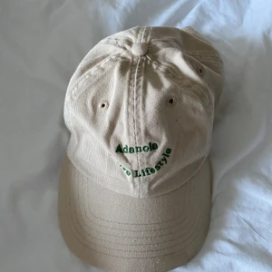 Keps Adanola - Beige keps från Adanola med grön text. Använd fåtal gånger. Ställbar och unisex. Köparen står för frakt💓