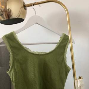 Jag säljer detta jätte fina gröna linne med fina spetsdetaljer runt sömmarna❤️❤️❤️säljer då de inte kommit till användning💕ändats använd en gång, därmed fint skick! 