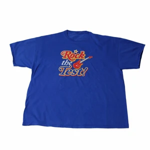 Rock The Test - Vintage Graphic T-shirt - En riktigt Nice blå tröja som har ett riktigt fett flerfärgat tryck över bröstet. Är perfekt när man gillar en lite baggy  outfit som har många detaljer från nittiotalet. Köpt på en thriftstore i USA som heter Out Of The Closet