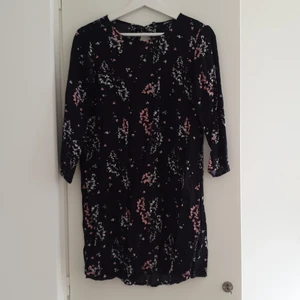 Svart klänning med blommor🌺🌸 - Skön sommarklänning i svart med rosa och vita blommor. Slutar ovanför knäna (är 171cm)