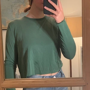 Croppad grön topp - Välanvänd men super skön. Säljs inte på Weekday längre. En liten fläck därför är priset sänkt. 