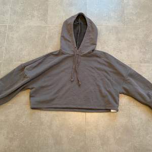 En mörk grå croppad hoodie från Gina tricot i stl M, helt oanvänd