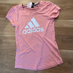 Adidas tröja - Rosa trängings topp från ADIDAS, superskön. Inte i ”vanligt tränings material” utan mer åt det ”tygigare” hållet. Som en vardags tröja helt enkelt. Osäker på storleken men uppskattar den som XS/XXS beroende på hur man vill ha den💓