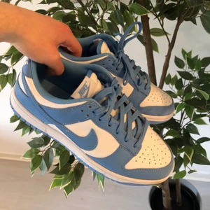 Nike Dunk Low ”UNC” 2021 modell - Säljer ett par dunks i storlek 42.5 som är inköpta och använda av mig, använt skorna max 10 gånger och alltid med crease skydd inlagt! Skorna är väldigt fräscha och inga flaws på dom. Säljes för 2800kr. Priset kan gå att diskuteras, hör av er i PM vid frågor/mer bilder! Skobox och kvitto går att ordna fram vid intresse.