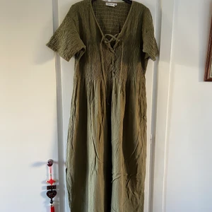 Vintage maxi-klänning - Lång mörkgrön klänning i lite indie-stil, väldigt bohemisk, hippiestil! Retro, typ 90-tal 😍💚👣 Storlek XL och stooor så passar 42+ då den är stretchig upptill! Jättefint skick FÖRUTOM ❗️OBS❗️den har en ca 10 cm lång reva baktill typ i höjd med knät!! Tänkte fixa den själv men har inte orkat, så nån annan kanske vi pyssla om den 💖💘 I övrigt superfint skick! 