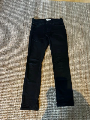 Svarta skinny jeans Stock & Hank - Snygga svarta skinny jeans från Stock & Hank. Klassisk femficksmodell med knapp och dragkedja framtill. Jeansen har en smal passform och är tillverkade i ett stretchigt material för extra komfort.