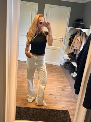 Vida vita jeans med hög midja - Säljer ett par snygga vita jeans med hög midja och raka, vida ben. 