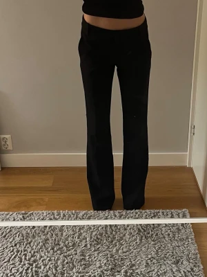 BikBok kostym byxor svarta - BikBok kostym byxor svarta 34.                              Aldrig använt, de är för stora. Jag är 162 cm (står på tå på bilden), de kan vara tall men jag är osäker. Priset kan diskuteras