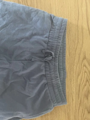 Blåa  mjukishorts från XOXO friends - Blåa mjukishorts från XOXO friends med dragsko i midjan och bred resår. Tillverkade i mjukt och bekvämt material, perfekta för chill dagar. Klassisk passform och enkel design utan tryck eller detaljer.