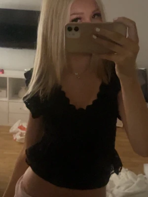 Svart spetsblus från Zara - Svart blus från Zara i spets med volangdetaljer och v-ringad hals. Modellen är croppad och har korta ärmar. Knappast använd därav säljer❣️
