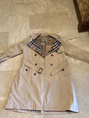 Beige trenchcoat Burberry - Trenchcoat burberry har fått den som present så vet tyvärr inte om den är äkta. Anledningen till varför jag säljer den är för att den passar inte mig men den är helt ny oanvänd