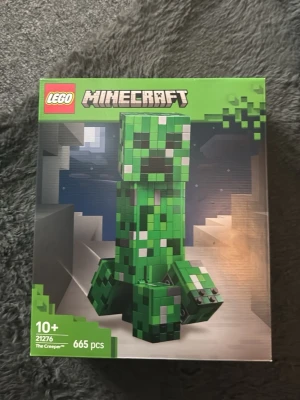 LEGO Minecraft Creeper 21276 - Säljer ett LEGO Minecraft-set, modell 21276, med 665 bitar. Bygg en stor Creeper-figur i gröna och svarta nyanser, samt en gris och TNT-block. Perfekt för Minecraft-fans som gillar att bygga och samla. Rekommenderas från 10 år.