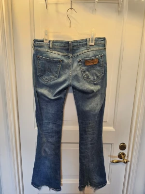 Lågmidjade jeans wrangler - Säljer ett par lågmidjade bootcut jeans från wrangler I storlek W28 och L32 pga att dem blivit för små för mig. Jeansen har slitage nere på benen som enligt mig ger en snygg look (kolla bilderna). Pris kan diskuteras. 