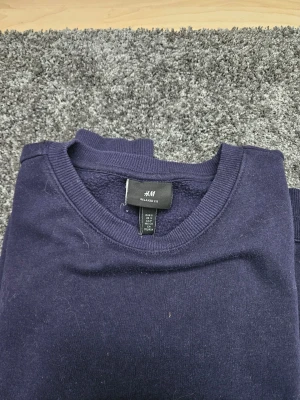 Mörkblå sweatshirt från H&M - En enkel och stilren mörkblå sweatshirt från H&M i relaxed fit. 