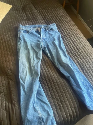 Blå raka jeans från Weekday - Säljer ett par klassiska blå jeans från Weekday i rak modell. Jeansen har fem fickor, normal midja och är gjorda i ett mjukt denimtyg. Perfekta för en avslappnad och stilren look.